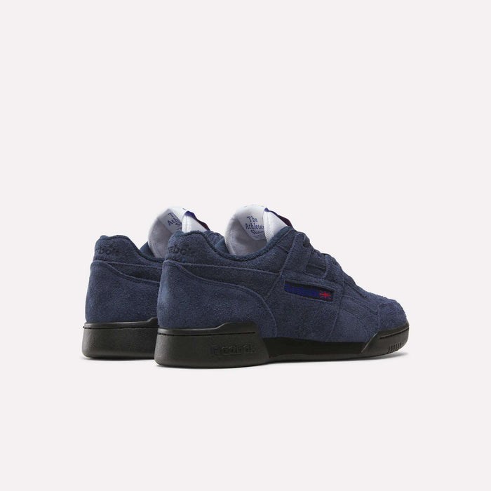 A pair of Reebok Workout Plus Shoes in navy blue suede with black soles, shown from back and side views, showcases classic '80s fitness style on a simple light background.