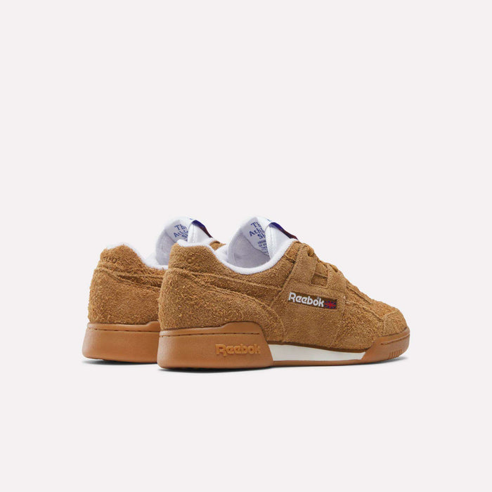 A pair of tan Reebok Workout Plus Shoes with textured suede uppers, brown soles, and Reebok branding on the side, evoke classic '80s fitness style. They are displayed against a plain white background.