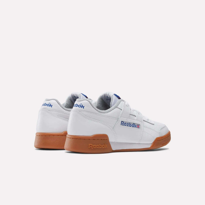 The Reebok Workout Plus Shoes feature a white low-top design with gum soles and blue/red branding, capturing classic '80s fitness style. Displayed on a plain white background.
