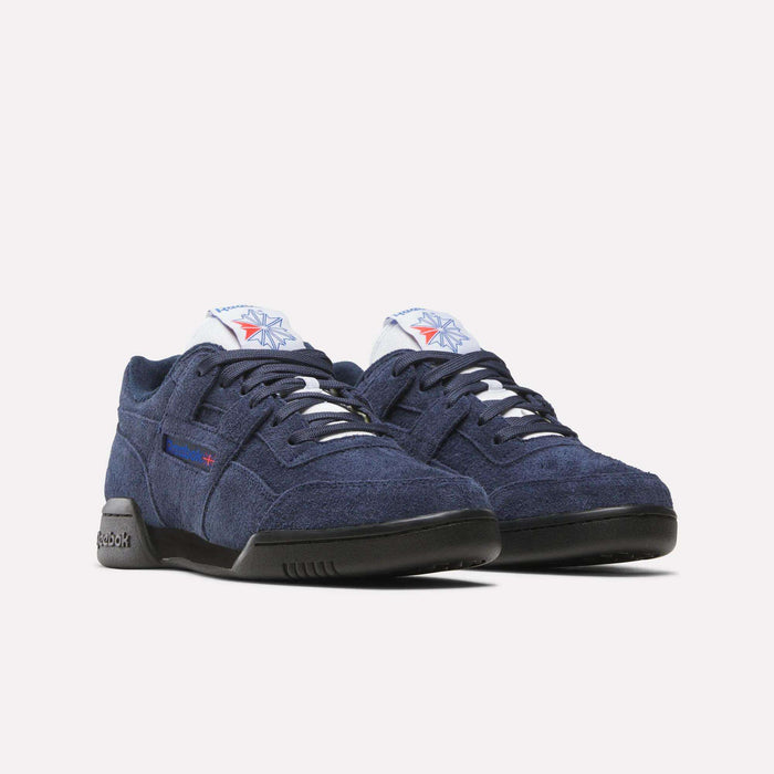 A pair of Reebok Workout Plus Shoes in navy blue suede with white laces, black soles, and Reebok logos on the side and tongue, showcasing iconic 80s style against a plain white background.