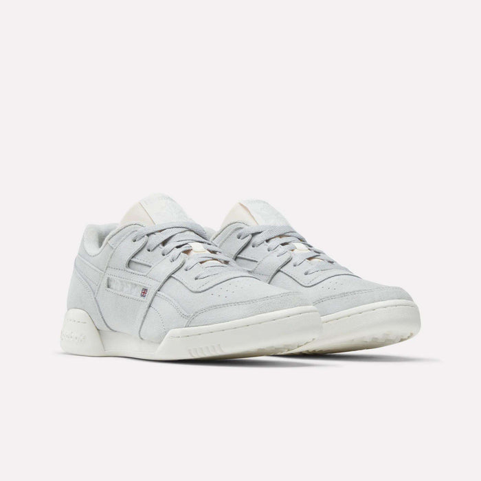 The Reebok Workout Plus Shoes are low-top sneakers in light gray suede with white soles, showcasing subtle stitching and classic '80s fitness style, displayed against a plain white background.