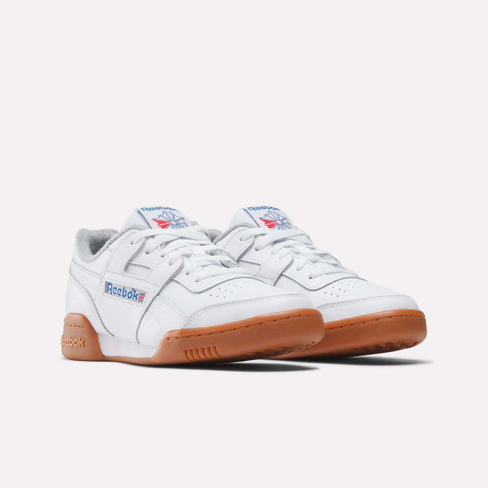 The Reebok Workout Plus Shoes in white feature gum rubber soles and blue and red logos on the side and tongue, highlighting classic '80s fitness style against a plain white background.