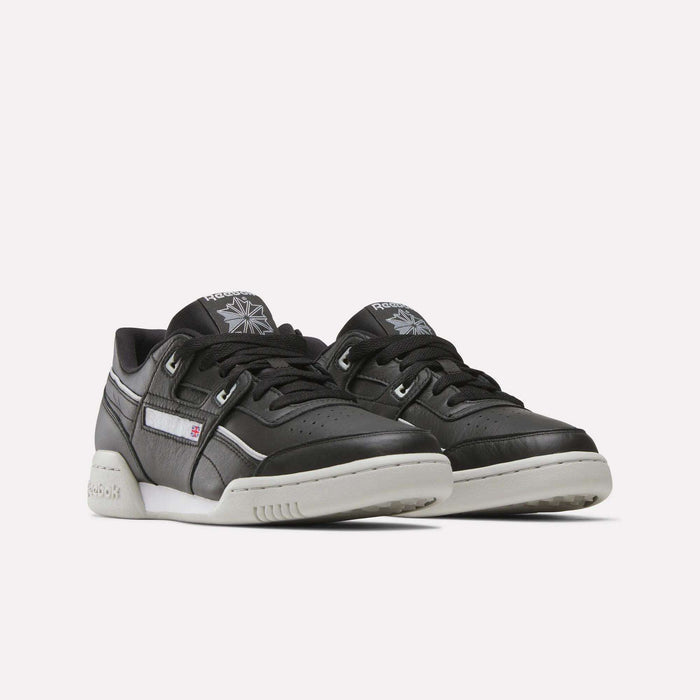 A pair of Reebok Workout Plus Shoes in black leather with white soles and subtle white accents, placed side by side on a plain, light background.