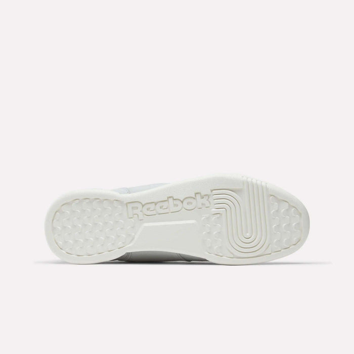 The image displays the sole’s bottom view of Reebok Workout Plus Shoes in white, featuring the Reebok logo and textured grip patterns for traction—a classic homage to '80s fitness style.