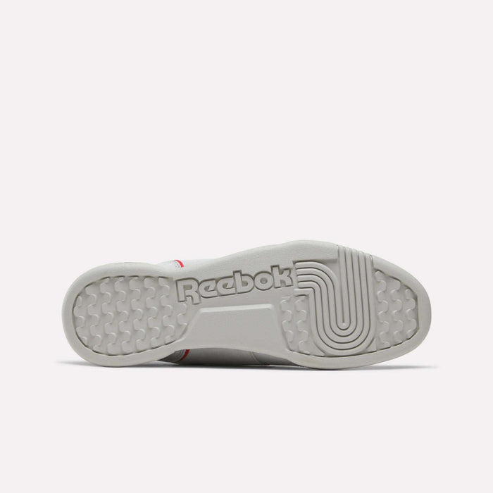 The sole of a white Reebok Workout Plus Shoe is displayed facing upward, prominently showcasing the Reebok logo in bold lettering along with textured tread patterns for grip, emphasizing the classic vintage touches that define these retro-inspired Workout Plus Shoes.