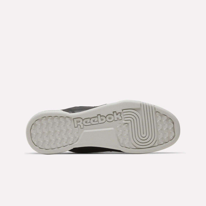The image shows the sole of the Reebok Workout Plus Shoes in light gray, featuring the Reebok logo and a combination of textured and linear grip patterns.