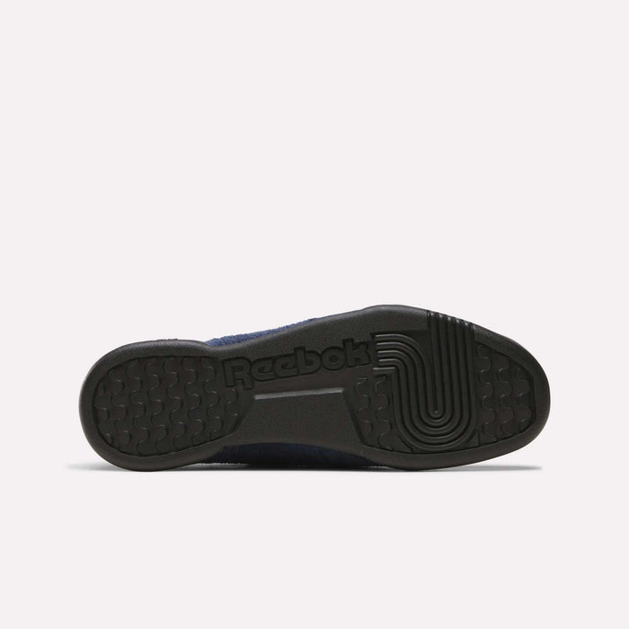 The image features the black rubber sole of Reebok Workout Plus Shoes, with a textured grip pattern and the Reebok logo. Set against a plain white background, it highlights the iconic 80s-inspired fitness style.