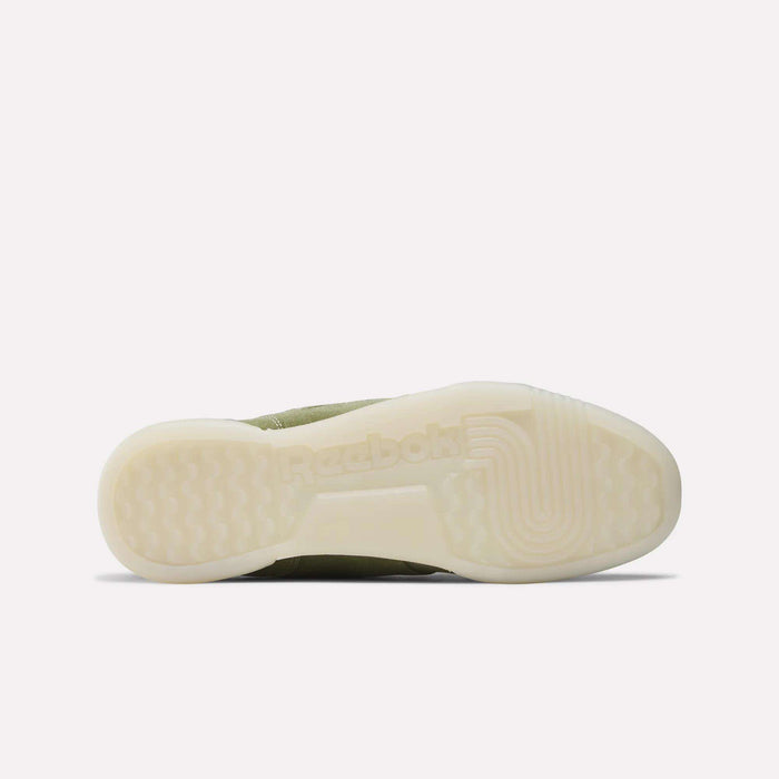 The image shows the bottom view of Reebok Workout Plus Shoes, featuring an off-white translucent sole with the Reebok logo and textured tread. The olive green upper adds to its classic '80s-inspired fitness style.