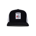 The Reebok Woven Patch Vector Trucker Cap features a black and white design, curved brim, mesh back, adjustable snapback, and a front woven patch with the Reebok logo plus a bold red accent.