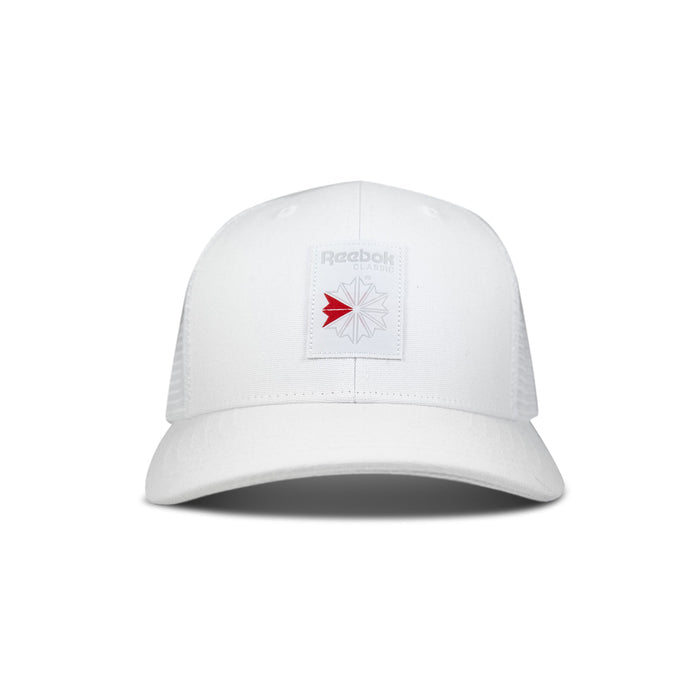 The Reebok Woven Patch Vector Trucker Cap is a white cap with mesh back panels and a rectangular patch on the front featuring the Reebok logo in gray with a red accent.