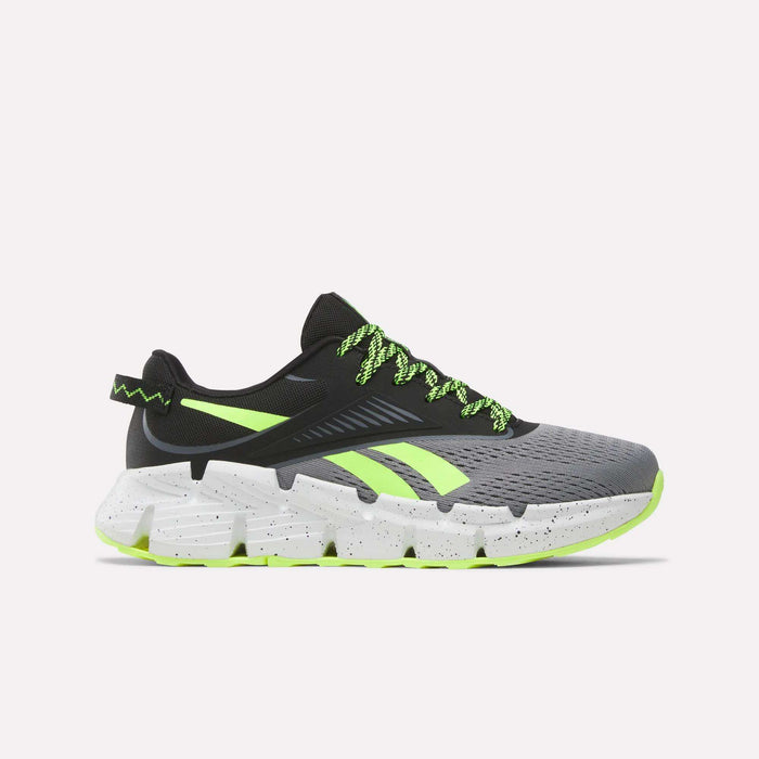 The Reebok Zig Dynamica 6 Running Shoes for big kids in Grey 4/Black/Digital Lime feature neon laces, black detailing, and a chunky speckled sole—engineered with Zig technology for superior running performance.