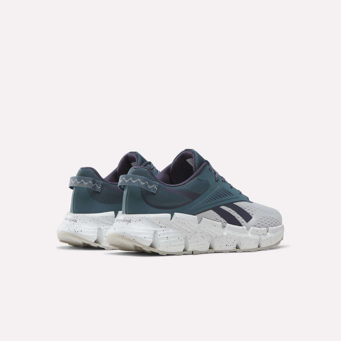 Pair of teal and gray Reebok Zig Dynamica 6 Running Shoes for big kids, featuring chunky white speckled soles with Zig technology, shown from the back and side against a plain light background.