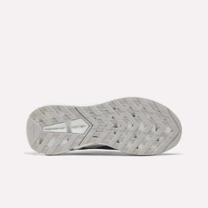 The image displays the gray, textured sole of the Reebok Zig Dynamica 6 Running Shoes for Big Kids, featuring a distinctive zigzag tread pattern with Zig technology, as seen from the bottom against a plain white background.
