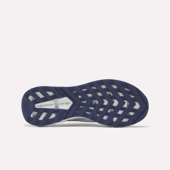 Navy blue and white shoe sole with a geometric tread pattern, photographed from the bottom against a white background to highlight the innovative Zig technology featured in the Reebok Zig Dynamica 6 Running Shoes for big kids.