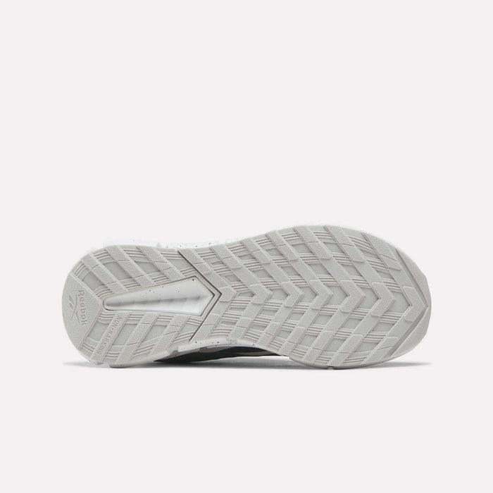 The image shows the bottom view of a white sole from the Reebok Zig Dynamica 6 Running Shoes for little kids, featuring a herringbone tread pattern and innovative Zig technology.