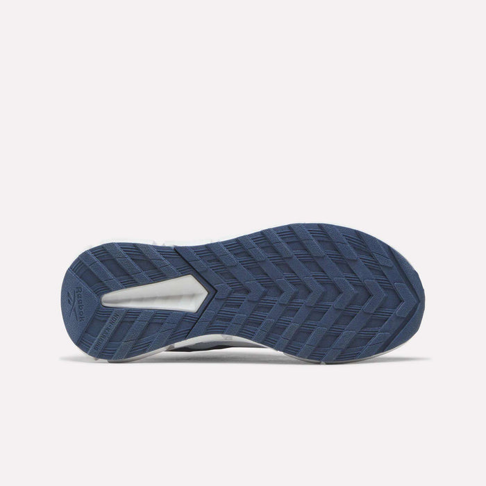 A blue outsole with a herringbone tread pattern and a white rectangular cutout in the midfoot area, designed for the Reebok Zig Dynamica 6 Shoes - Little Kids, featuring a Floatride EVA midsole, shown against a plain white background.