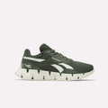 The Zig Dynamica STR Shoes by Reebok feature an olive green mesh upper, white jagged sole, and white side stripes, displayed in a side profile against a plain light background.