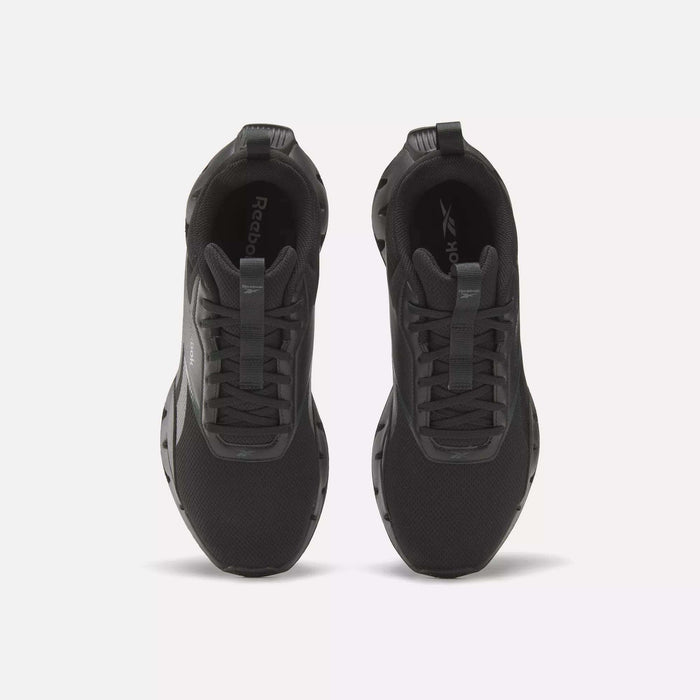 A pair of Reebok Zig Dynamica STR Shoes in black is shown from above, highlighting the laces, tongue, and branded insoles on a plain light background—progressive running shoes combining comfort and style for daily wear.