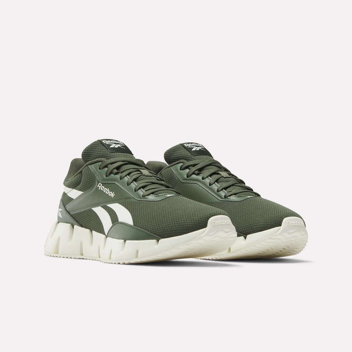 The Reebok Zig Dynamica STR Shoes in olive green feature white soles, white stripe detailing, and breathable mesh for comfort, displayed on a plain white background.
