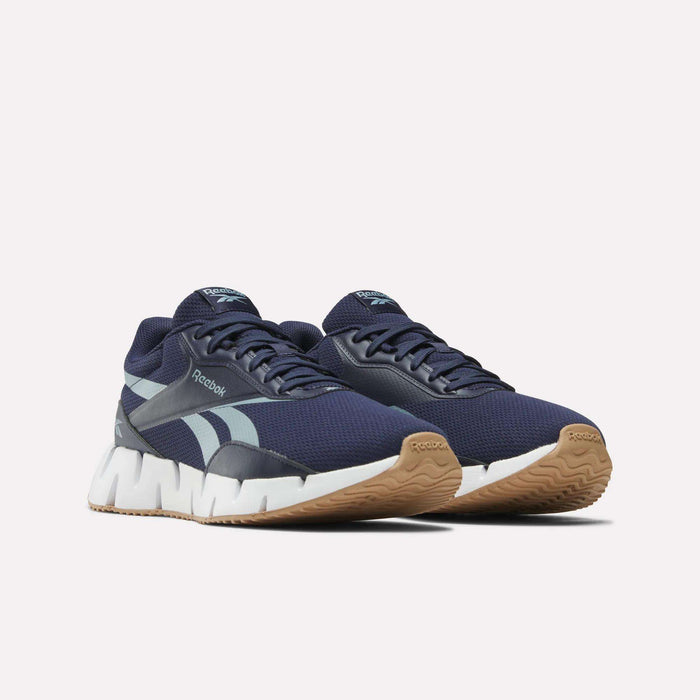 A pair of Reebok Zig Dynamica STR Shoes in navy blue with a breathable mesh upper, light blue accents, white zigzag midsoles, and tan rubber outsoles, shown on a plain white background.