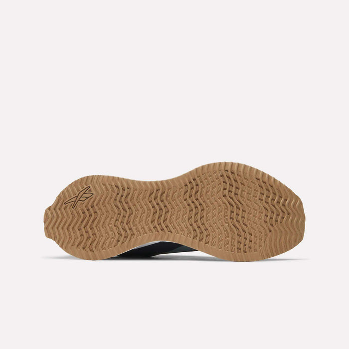 The image displays the bottom view of Reebok Zig Dynamica STR Shoes, featuring a light brown, textured rubber outsole with a wavy zigzag tread pattern and a small logo near the heel. The background is plain white.