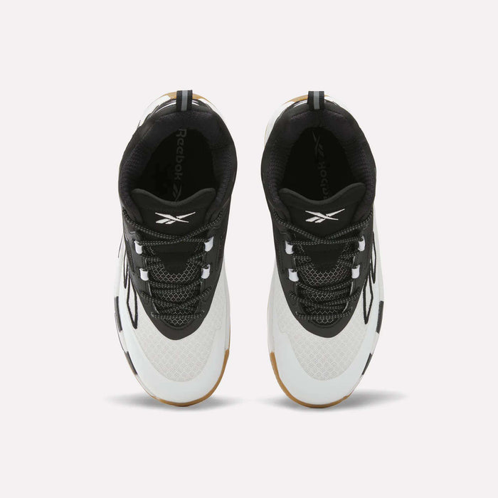 Top view of a pair of Zone Breaker Shoes - Big Kids by Reebok, featuring black uppers, white toes, white midsoles, and gum soles. Placed side by side on a light background, these basketball shoes are designed for both style and ankle support.