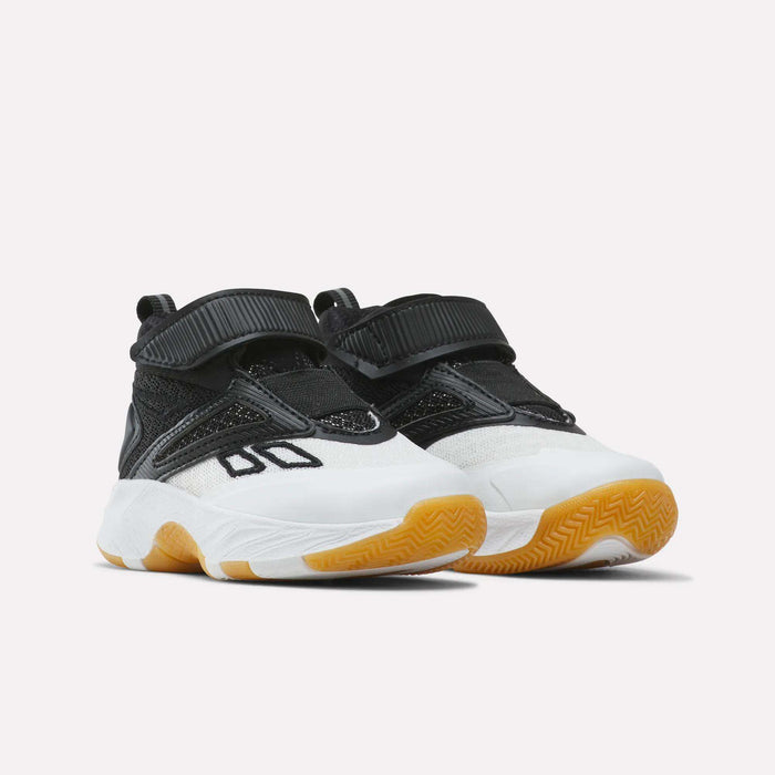 The Reebok Zone Breaker Shoes - Toddler are a pair of black and white athletic sneakers featuring velcro straps, mesh accents, thick white midsoles, and gum-colored rubber outsoles; these shoes offer a supportive ankle design to keep toddler boys comfortable during every activity.