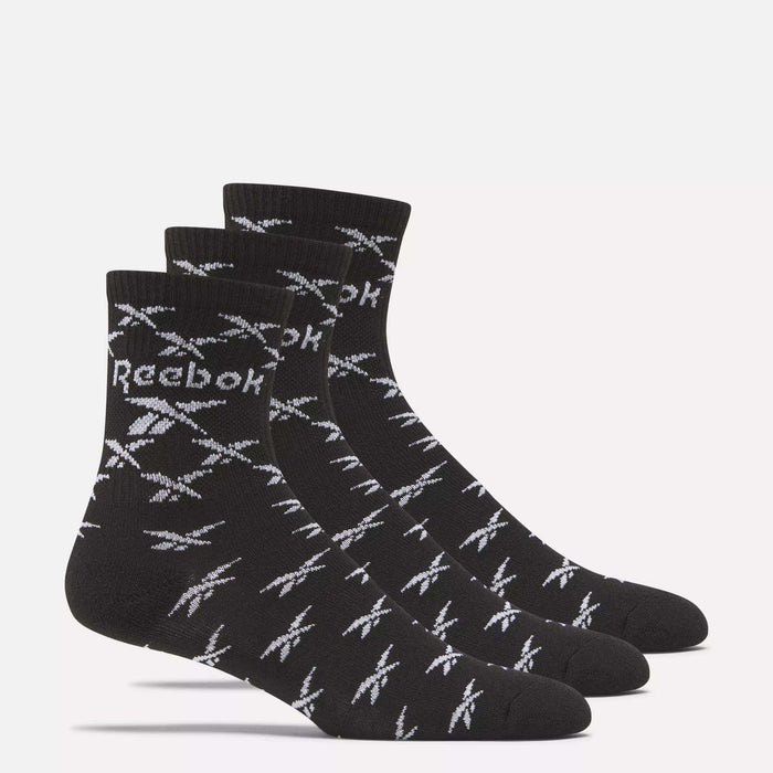 Three pairs of Reebok Zone Cushion Mid Crew Socks are shown side by side, each black with white Reebok logos and patterns, on a plain light background.